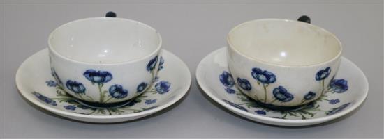Two Macintyre Burslem Blue Poppy pattern white ground cups and saucers, early 20th century saucer 14cm, one cup and saucer restored